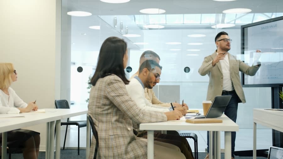 Formateur expliquant un modèle à une équipe attentive, écran de présentation en fond